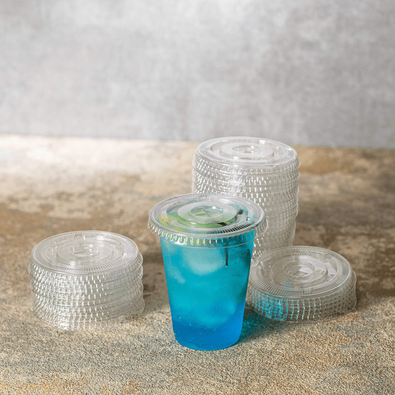 Karat PET Clear Flat Lid for 7oz PET Cup on matching cup filled with blue drink