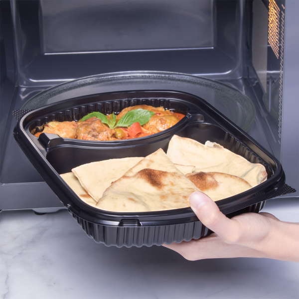 Karat 36 oz PP Plastic Microwaveable Black Take Out Box with 2 compartments with naan and curry going into microwave