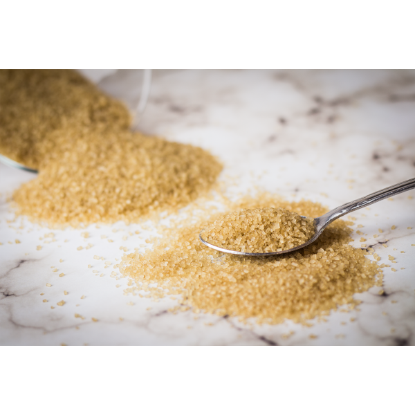 raw cane sugar being scooped into a spoon