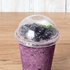 Clear Karat 95mm PP Plastic Dome Lids on matching clear cup with blueberry smoothie