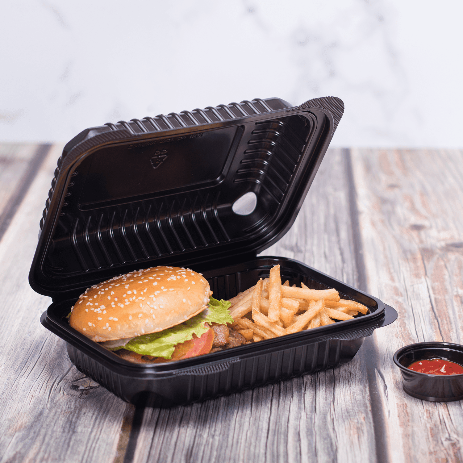 Black Karat 9'' x 6" PP Plastic Hinged Container with a burger and fries inside