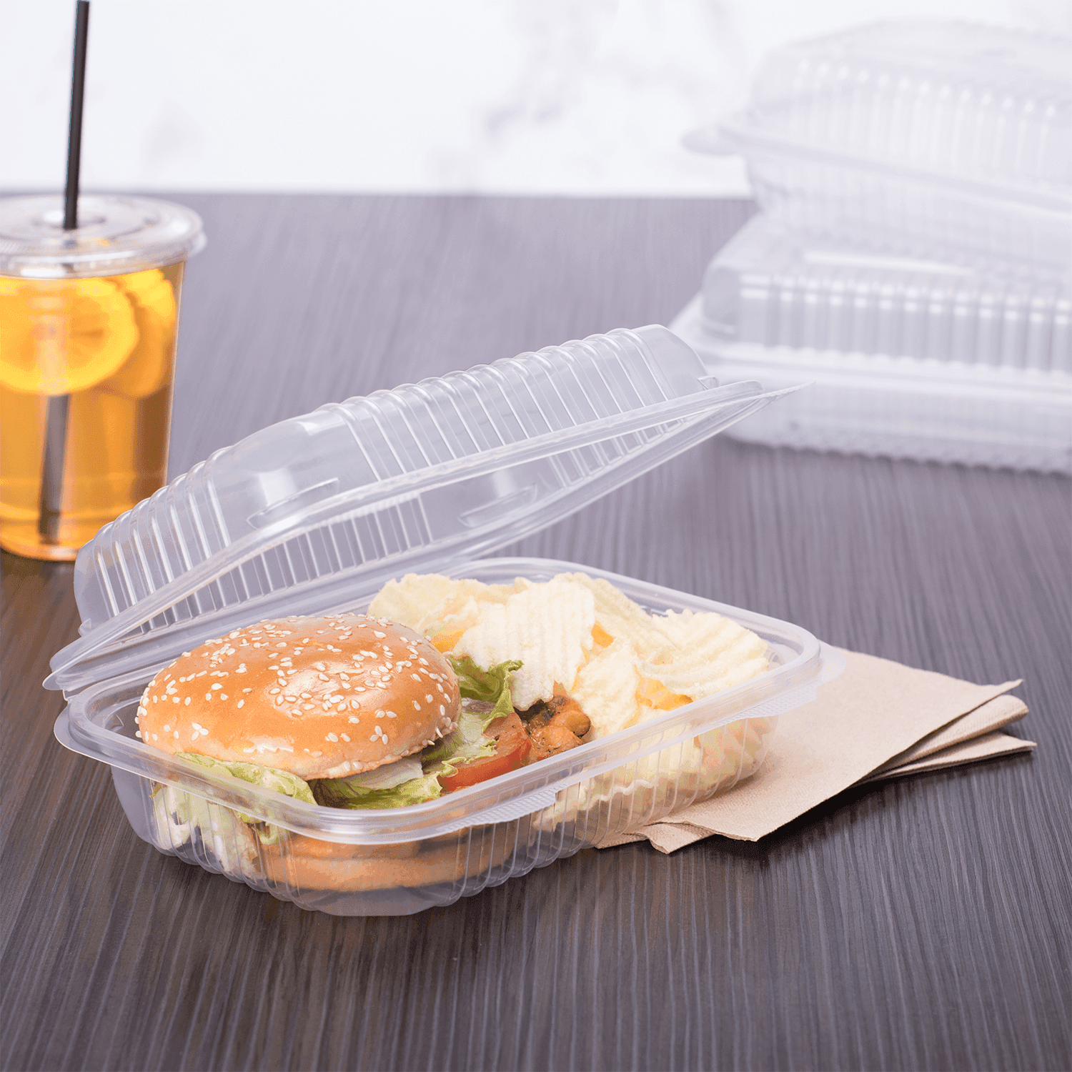 Clear Karat 9'' x 6" PP Plastic Hinged Container stacked with a burger and chips