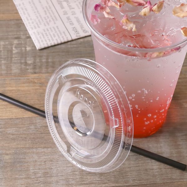 Clear Karat 98mm PET Plastic Flat Lids beside matching clear cup