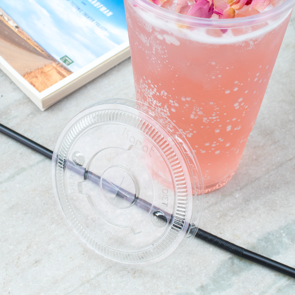 Clear Karat 104.5mm PET Plastic Flat Lids on pink drink