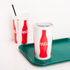 Coca Cola Print Karat 44oz Paper Cold Cups with flat lid on serving tray