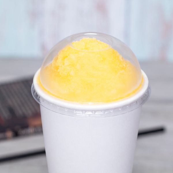 Clear Karat 90mm PET Dome Lid for 12-22 oz Paper Cold Cup on paper cup with yellow iced drink