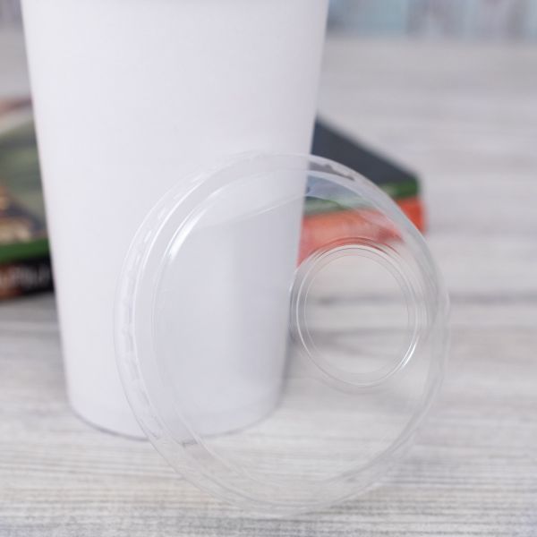 Clear Karat 90mm PET Dome Lid for 12-22 oz Paper Cold Cup next to matching paper cup