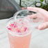 Clear Karat 104.5mm PET Plastic Flat Lids on pink drink