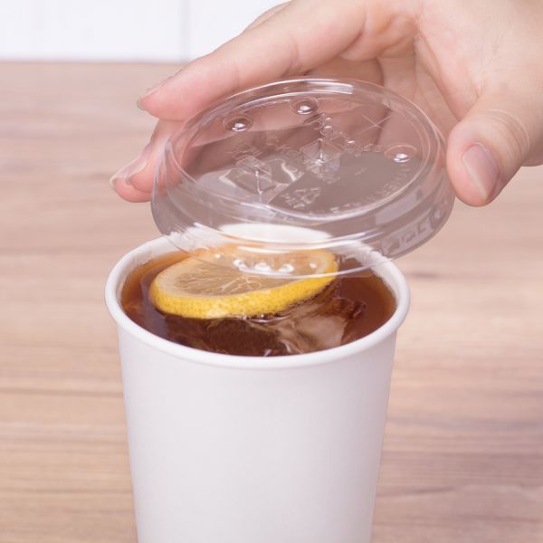 Clear Karat 90mm PET Plastic Strawless Sipper Lids on matching paper cup with tea inside