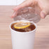 Clear Karat 90mm PET Plastic Strawless Sipper Lids on matching paper cup with tea inside