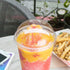 Clear Karat 107mm PET Plastic Dome Lid on cup with smoothie