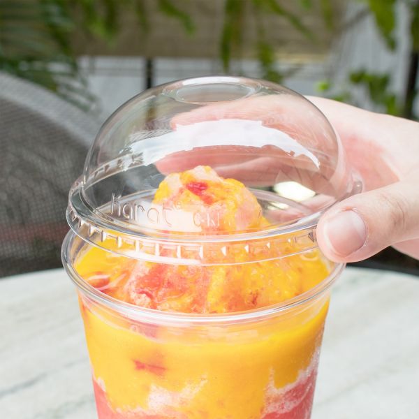 Clear Karat 107mm PET Plastic Dome Lid on cup with smoothie