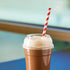 Clear Wide Opening Karat 98mm PET Plastic Dome Lids on matching clear cup with chocolate shake and paper straw