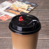 Black Karat 90mm Sipper Dome Lid for 16/24 oz Tall Premium PP Plastic Cup on matching cup with a latte