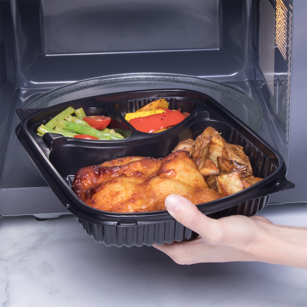 Karat 36 oz PP Plastic Microwaveable Black Take Out Box with 3 compartments, chicken, and vegetables