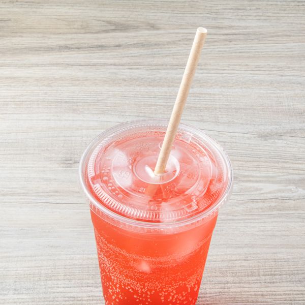Kraft Karat Earth 10.25" Paper Jumbo Straw Paper Wrapped in orange drink with clear cup