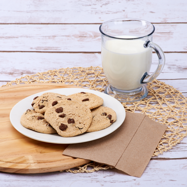 Kraft Karat 12"x13" Off-Fold Napkins beside cookies and milk