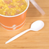 White Karat PS Plastic Medium Weight Soup Spoon next to a container of soup